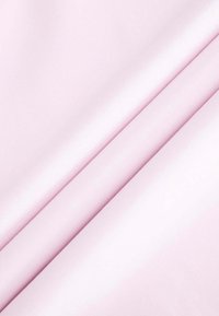  Lichtroze katoenen stof met een zachte textuur, met subtiele plooien die een gelaagd uiterlijk creëren. Geen patronen of opvallende accenten aanwezig.