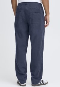 Navy chino pants with elastic waistband, two back pockets, and straight-leg design. Smooth texture, cotton-blend fabric, and relaxed fit.