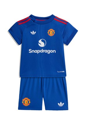 Equipación de fútbol azul del Manchester United para niños con rayas rojas en los hombros, logotipo de Snapdragon, logotipos de Adidas y escudos del equipo en la camiseta y los pantalones cortos.