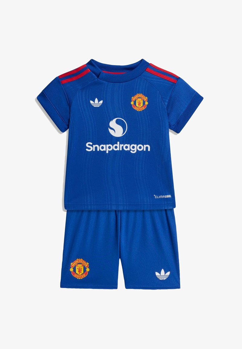 Μπλε ποδοσφαιρική στολή της Manchester United για παιδιά με κόκκινες ρίγες στους ώμους, λογότυπο Snapdragon, λογότυπα Adidas και έμβλημα της ομάδας σε μπλούζα και σορτς.