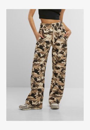 Camo-patterned sweatpants in beige, brown, and black; loose fit with an elastic drawstring waist; pockets on the sides.