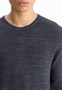 Dunkelblaues Rundhalspullover mit strukturiertem Strickmuster. Verfügt über einen gerippten Kragen und eine glatte Stoffoberfläche ohne sichtbare Logos oder Verzierungen.