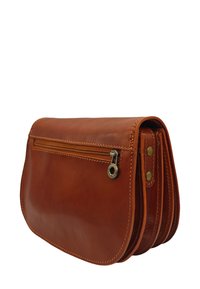 Pochette en cuir brun de forme courbée, avec une poche zippée, des coutures visibles et des accents en laiton. Texture lisse.