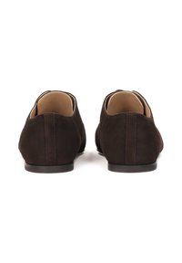 Zapatos de ante marrón oscuro con una textura suave, diseño minimalista, forma redondeada y una suela negra lisa y baja.