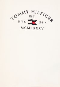 Felpa in cotone bianco con logo ricamato in nero e rosso, arricchita da un dettaglio grafico di forme sovrapposte.