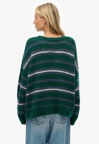 Jersey verde de gran tamaño con rayas horizontales en azul marino y crema, hecho de material borroso, con un escote redondeado y dobladillo acanalado.