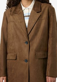 Rjav nubuk blazer z izrezanim ovratnikom, dvema sprednjima žepoma in zapenjanjem z enim gumbom. Gladka tekstura in krojen design.