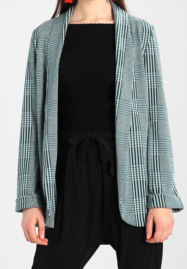 Rutig blazer i teal och svart, tillverkad av lättviktigt material med avslappnad passform, sjalkrage och uppvikta ärmslut. Bärs över en svart topp.