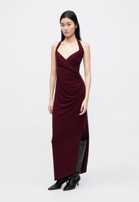 Bordové šaty na krk so zberaním, dĺžka po zem, s bočným rozparkom a priliehavým strihom; hladká, elastická látka.