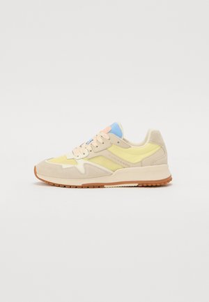 Beige and yellow sneaker with a suede and mesh upper, featuring pastel blue accents, light pink laces, and a textured rubber sole.