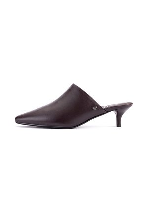 Mule de cuero marrón oscuro con punta puntiaguda y tacón bajo tipo kitten, estilo sin hebilla con un pequeño logo metálico en el lateral.