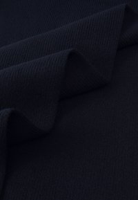Marineblauw ribstof met een gestructureerd oppervlak, met plooien en kreuken die zachtheid en flexibiliteit aangeven.