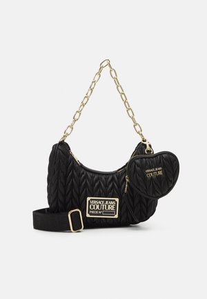 Sort quiltet håndtaske med guldkæde, guldlap med logo og fastgjort hjerteformet pung med Versace Jeans Couture branding.
