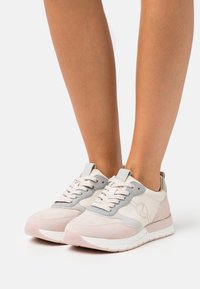 Lightweight sneakers in beige and grey, featuring a suede and leather upper, rounded toe, flat laces, and a cushioned white sole.