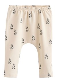 Pantalon beige pour bébé avec des imprimés de biberons noir et blanc et une ceinture élastique, avec un design à entrejambe basse.