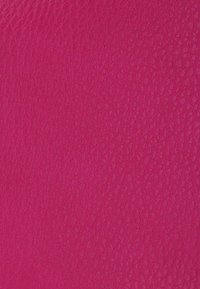 Surface en cuir texturé rose vif avec de petits grains irréguliers créant un aspect légèrement granuleux.