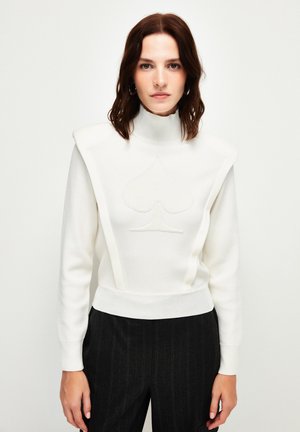 Weißer gestrickter Pullover mit hohem Kragen, Schulterpolstern und einem erhöhten Spatenlogo. Strukturiertes Material mit taillierter Passform und langen Ärmeln.