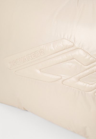 Beige padded cushion featuring a glossy texture, embossed "DSQUARED2" logo, and subtle stitching detail in a geometric pattern.
