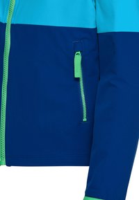 Μανίκι μπουφάν σε μπλε και τυρκουάζ με πράσινες λεπτομέρειες φερμουάρ στην μπροστινή τσέπη και το κύριο φερμουάρ.