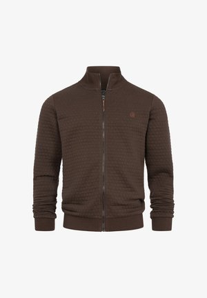 Brun quiltet jakke med lynlås, ribstrikkede ærmegab og krave, med en lille rund logo på venstre bryst.