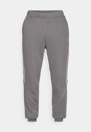 Grijze sweatpants met een relaxte pasvorm, voorzien van witte en zwarte zijstrepen, een elastische tailleband en boordjes aan de enkels. Gemaakt van zachte stof.