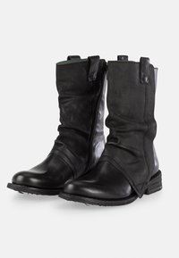 Botas de tobillo de cuero negro con un diseño desaliñado, que cuentan con una cremallera lateral, paneles texturizados y un tacón apilado para mayor estabilidad.