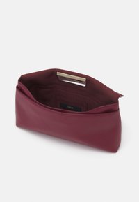 Pochette en cuir bourgogne avec une texture lisse, un design minimaliste et un accent en métal doré en haut. L'intérieur comprend plusieurs poches.