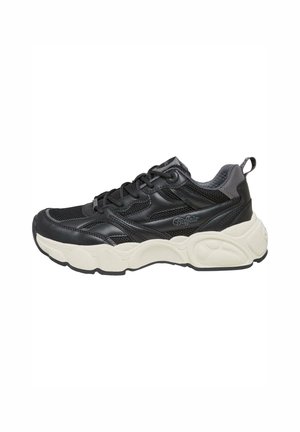 Scarpa sportiva nera con parte superiore in mesh, dettagli in pelle, suola spessa di colore crema e sistema di allacciatura con linguetta sul retro.