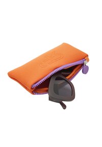 Pomarańczowy pokrowiec na okulary z tkaniny, z fioletowym zamkiem błyskawicznym i uchwytem, częściowo otwarty, ukazujący ciemne okulary o charakterystycznym kształcie.