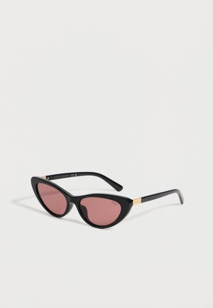 Lunettes de soleil noires forme œil de chat avec verres roses et détails dorés sur les branches, avec logos Polo Ralph Lauren.