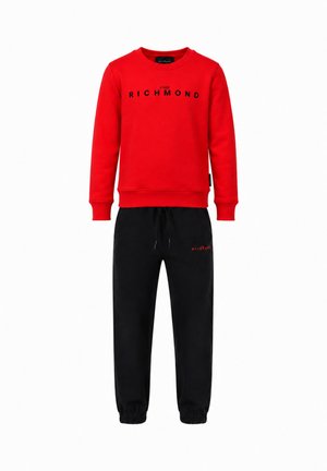Felpa rossa a maniche lunghe con testo "John Richmond" e pantaloni jogger neri con polsini elastici e piccolo logo rosso sulla coscia sinistra.
