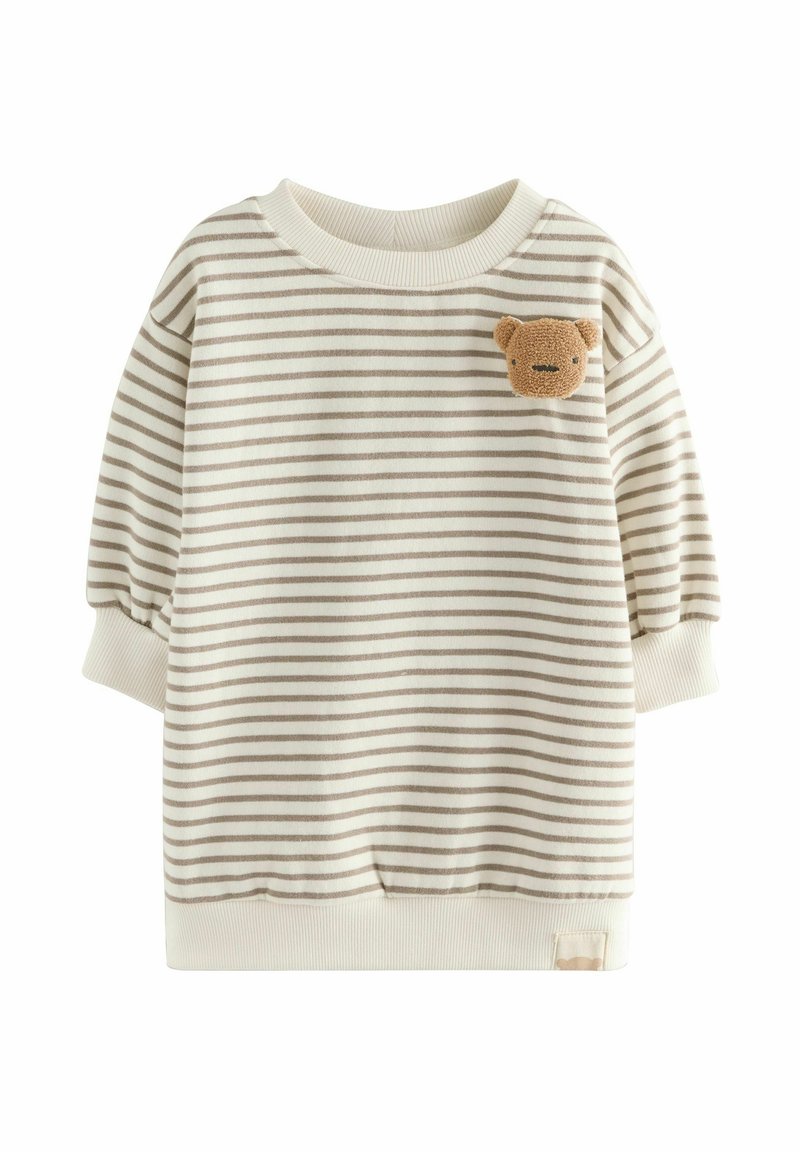 Sweatshirt rayé crème et marron clair avec une coupe ample. Présente un patch en peluche en forme d'ours sur la poitrine et des poignets côtelés aux manches.