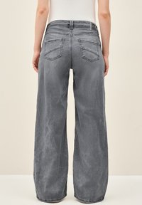 Grijze denim jeans met wijde pijpen en een vervaagde afwerking, voorzien van twee achterzakken en een gestikte tailleband. Uitgerust met een leren logo patch.