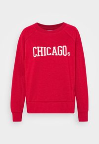 Felpa rossa con collo rotondo e maniche raglan. Presenta la scritta "CHICAGO" in lettere bianche sulla parte anteriore. Tessuto morbido.