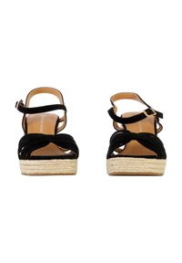 Sandali espadrilles in suede nero con suola in juta intrecciata, caratterizzati da un design a fascia incrociata e una cinghia alla caviglia con chiusura a fibbia.
