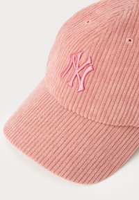 Pink corduroy baseball cap with embroidered logo, structured shape, and visible ribbed texture. Features six ventilation eyelets.