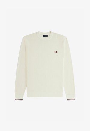 Cremefarvet strikket sweater med rund hals, ribbede manchetter og et lille marsala-emblem på brystet. Tekstur med et vaffelmønster.