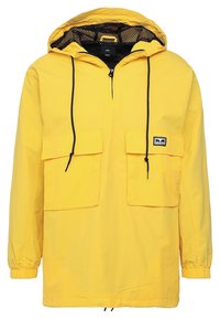 Yellow waterproof anorak with a mesh-lined hood, black drawstrings, two front pockets, and elastic cuffs. Smooth texture, lightweight design.