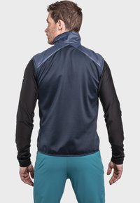 Herrenweste mit hohem Kragen in Dunkelblau, verfügt über eine glatte Vorderseite und strukturierte schwarze Ärmel. Das Design enthält ein kontrastierendes Schulterpaneel.