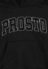 Czarna bluza z kapturem z wyraźnym białym logo "PROSTO" wyszytym na piersi, z kieszenią kangurzą z przodu. Miękki, teksturowany materiał.