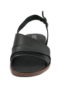 Sandalo in pelle nera con cinturini incrociati, design open toe e suola rotonda in legno. Presenta una cinghia alla caviglia regolabile.