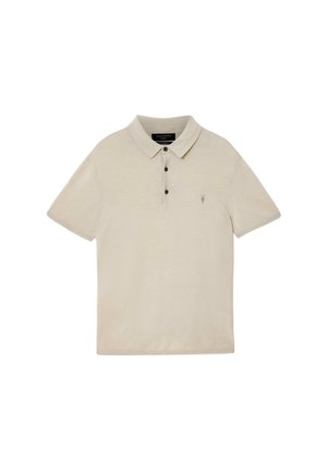 Beige polo met korte mouwen, drie donkere knopen en een klein geborduurd logo op de linkerborst.