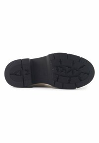 Suela de goma negra con patrón de textura, que presenta profundas ranuras y un centro liso. Nombre de la marca claramente marcado en el lateral.