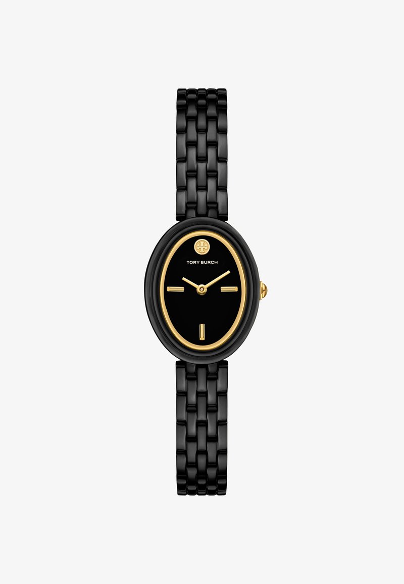 Musta soikea kello, jossa on kultasävyinen kehys ja musta kellotaulu. Varustettu mustalla linkkihihnalla ja kolmella kultaisella viisariella. Logo kellon 12 kohdalla.