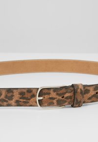 Opasek s leopardím potiskem vyrobený z texturované hnědé semišové kůže, se stříbrnou kovovou sponou a hladkým vnitřkem z tanové kůže.