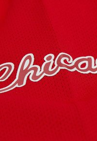 Roter Stoff mit einer strukturierten Oberfläche, auf dem das Wort "Chicago" in weißen, stilisierten Buchstaben steht. Das Design ist auffällig und klar.
