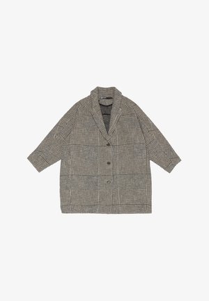 Płaszcz w czarno-białą kratę o luźnym kroju, szerokie klapy i trzy guziki na przodzie. Wykonany z fakturowanej tkaniny.