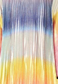 Abito plissettato con una gradazione di blu, viola, rosa e giallo, caratterizzato da una texture metallica lucida che riflette la luce.