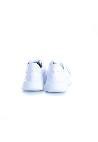 Baskets en cuir blanc avec semelle plate, devant à lacets et design minimaliste avec marquage au talon arrière. Texture lisse dans l'ensemble.