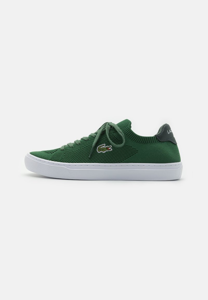Sapatilha em malha verde com biqueira redonda, sola branca plana e atacadores a condizer. Apresenta um pequeno logo na lateral e um cabedal texturizado.